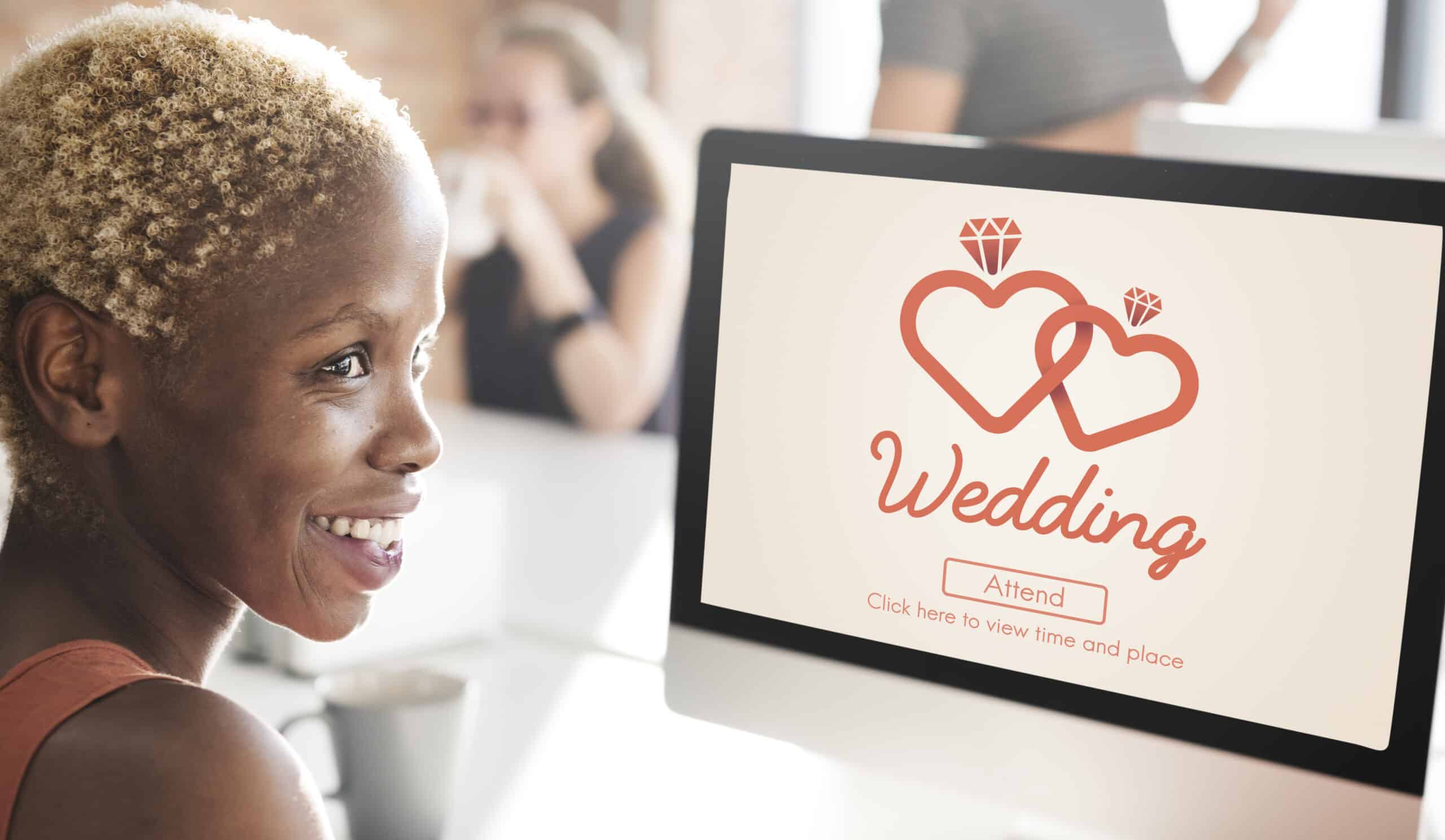 Woman sitting at computer viewing online wedding invitation