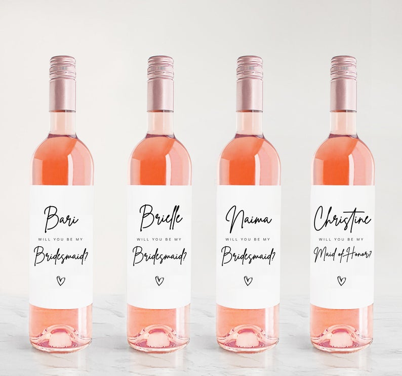 4 botles of Rose with customized labels that say "will you be my bridesmaid?"