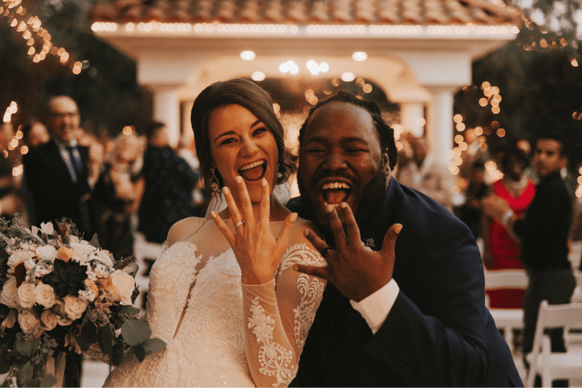 Couple shows off their wedding rings at wedding reception