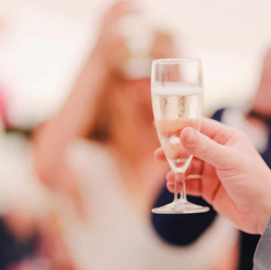 Hand holding champagne for maid of honor toast