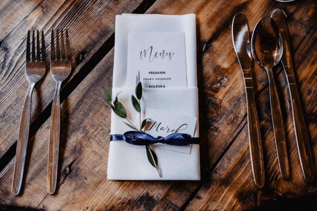 Wood table with dinnerware and linen napkin with name place card and menu